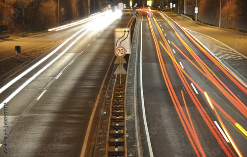 Car lights on german highway construction site with signs at night, long exposure photo of traffic