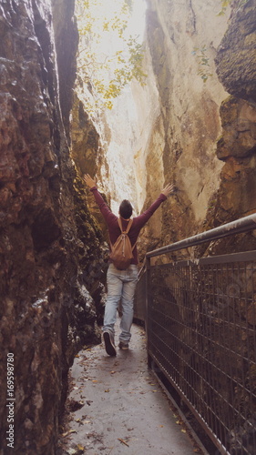 Hombre joven haciendo una ruta de senderismo entre unas montañas rocosas