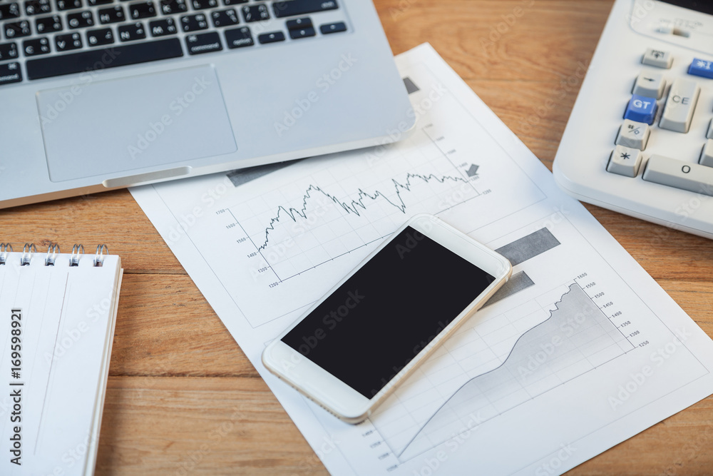 Open laptop with digital tablet and white smartphone, business and investment concept Open laptop with digital tablet and white smartphone, business and investment concept
