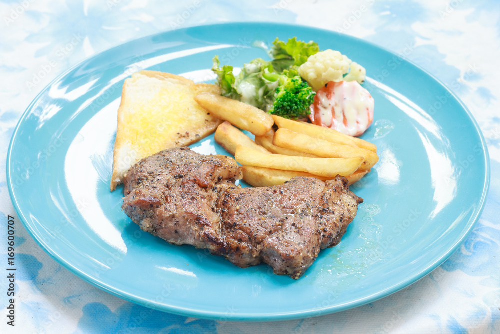 Grilled steak with french fries and vegetables and toast Grilled steak with french fries and vegetables and toast