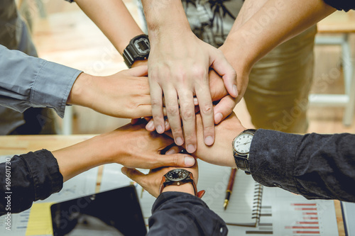 Business people join hands for teamwork.