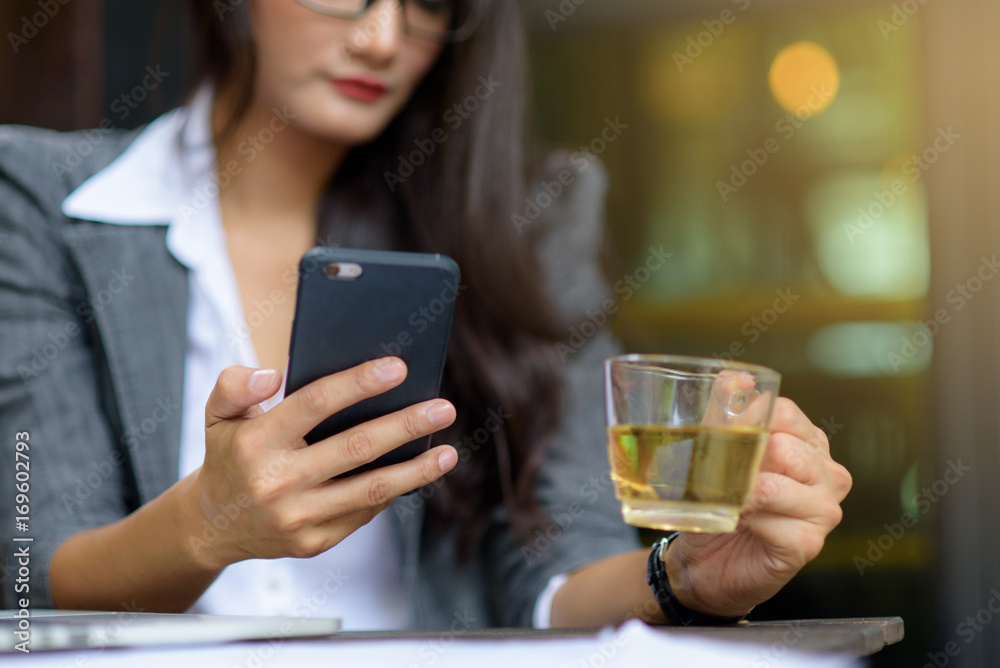 Young female freelancer checking email on cell during tea break. Business concept.