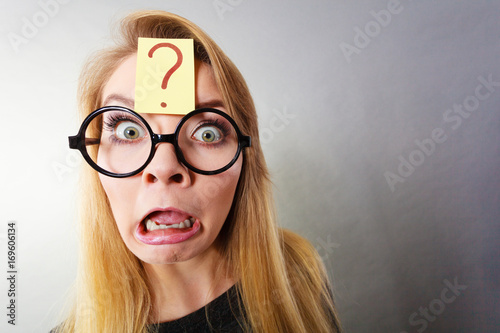 Weirdo nerd woman having question mark on forehead