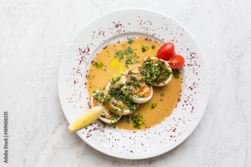 stuffed squid. Baked squid stuffed with onions, carrots and tmatoes.