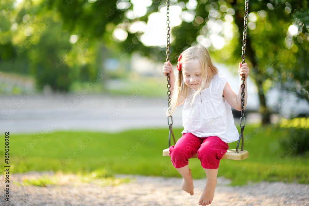 Cute little girl having fun on a playground outdoors in summer. Cute little girl having fun on a playground outdoors in summer.