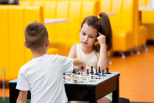 Little boy and girl play chess