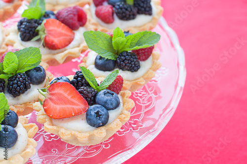 Mini tarts on the plate close up. Homemade dessert with delicious catalonian traditional cream and fresh berries