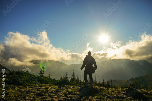 A Person Standing on the Mountain with Clouds During Sunset/Sunrise © nat693