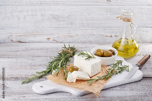 Fresh feta cheese with rosemary on white wooden serving board