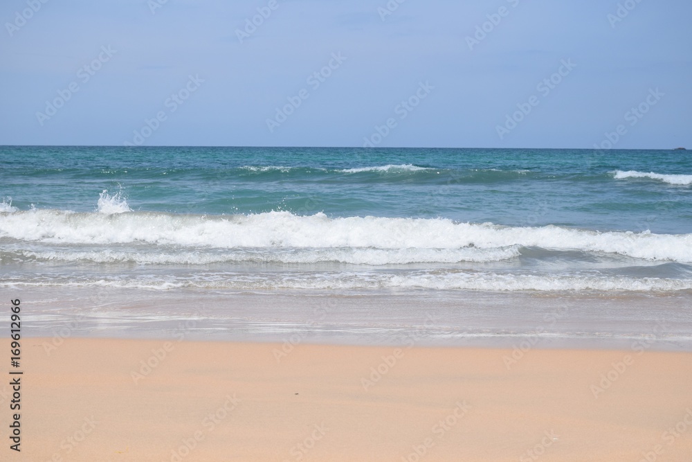Strand mit Liegestühlen, Sonnenschirm und blauem Meer