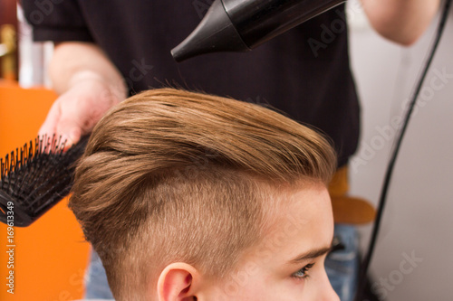 little boy getting haircut by barber