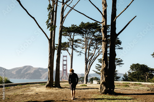 Young man wandering around the coast near the golden gate bridge photo