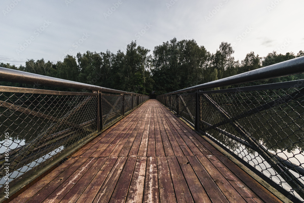 Fototapeta premium Old faded wooden bridge perspective view