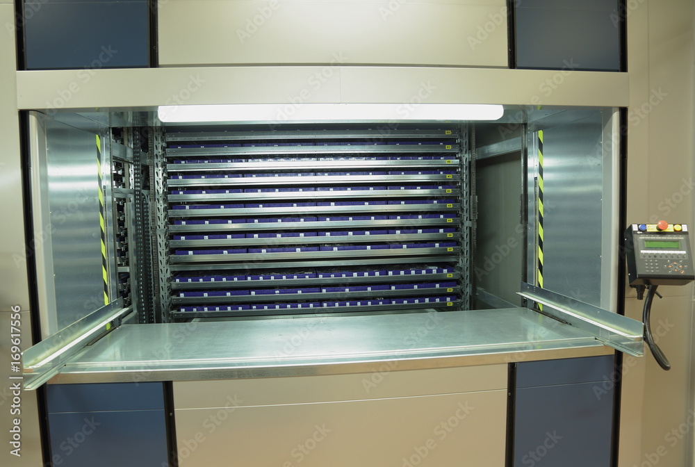 Automated storage system in the warehouse.Vertical carousel storage unit Automated storage system in the warehouse.Vertical carousel storage unit