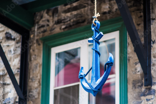 Closeup of hanging blue anchor decoration in urban city