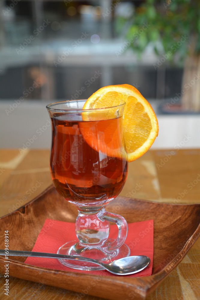 Transparent cup of black tea with slice orange on wooden background. Transparent cup of black tea with slice orange on wooden background.