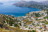 aerial view of the coastline and the Panteli village, a traditional Greek village with white buildings and fishing boats, Leros island, Greece