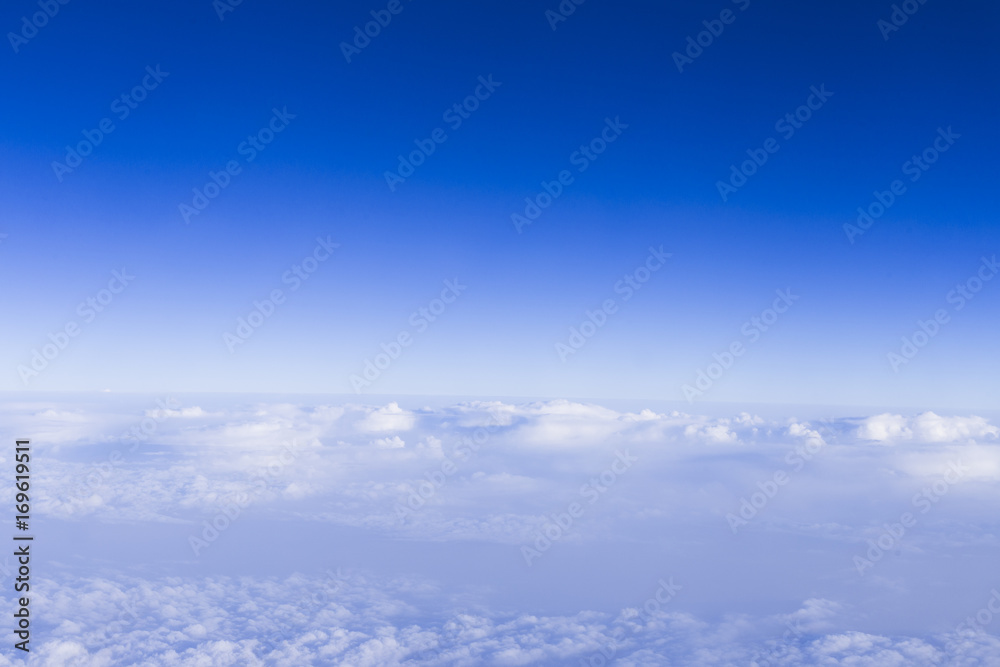 clear blue sky background with white beautiful clouds. View from the window airplane. Travel concept