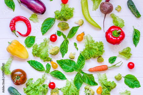 Collection of fresh organic vegetables and greeens on white wooden table. Top view. Healthy foods, cooking and vegetarian concept background. Selective focus photo