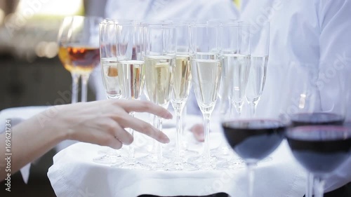 The waiters greet guests with alcoholic drinks. Champagne, red wine, white wine on trays. photo