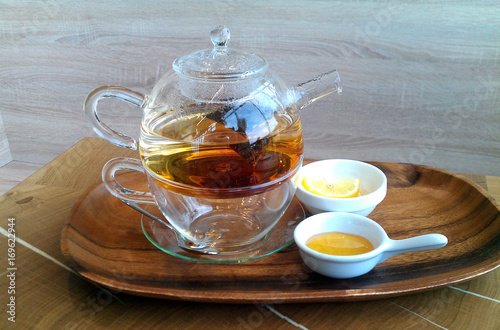 Green hot tea on a teapot on a wooden background.