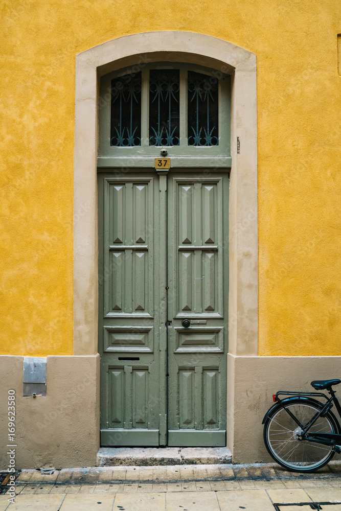 Green doors with yellow wall in France