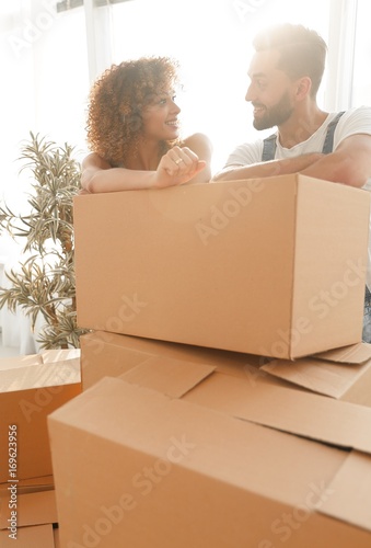 Happy couple standing near boxes in their new apartment.