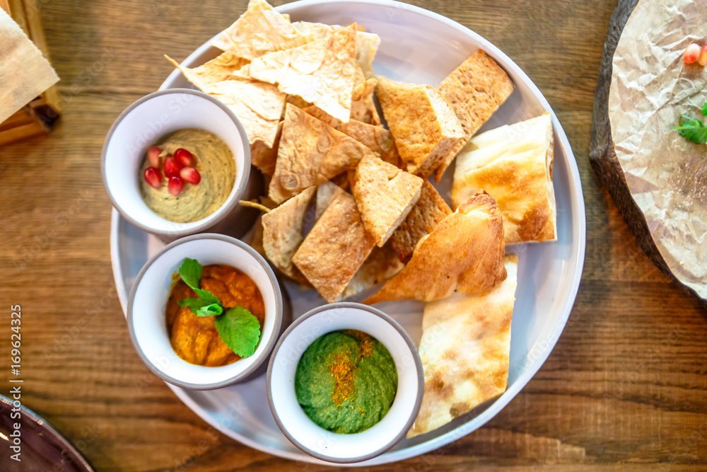 Pieces of different bread and sauces are on the plate. Pieces of different bread and sauces are on the plate.