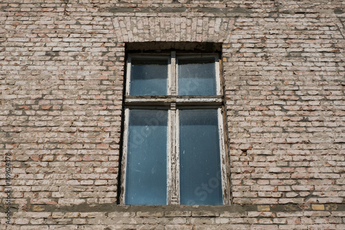 old wooden wndow on run down building facade