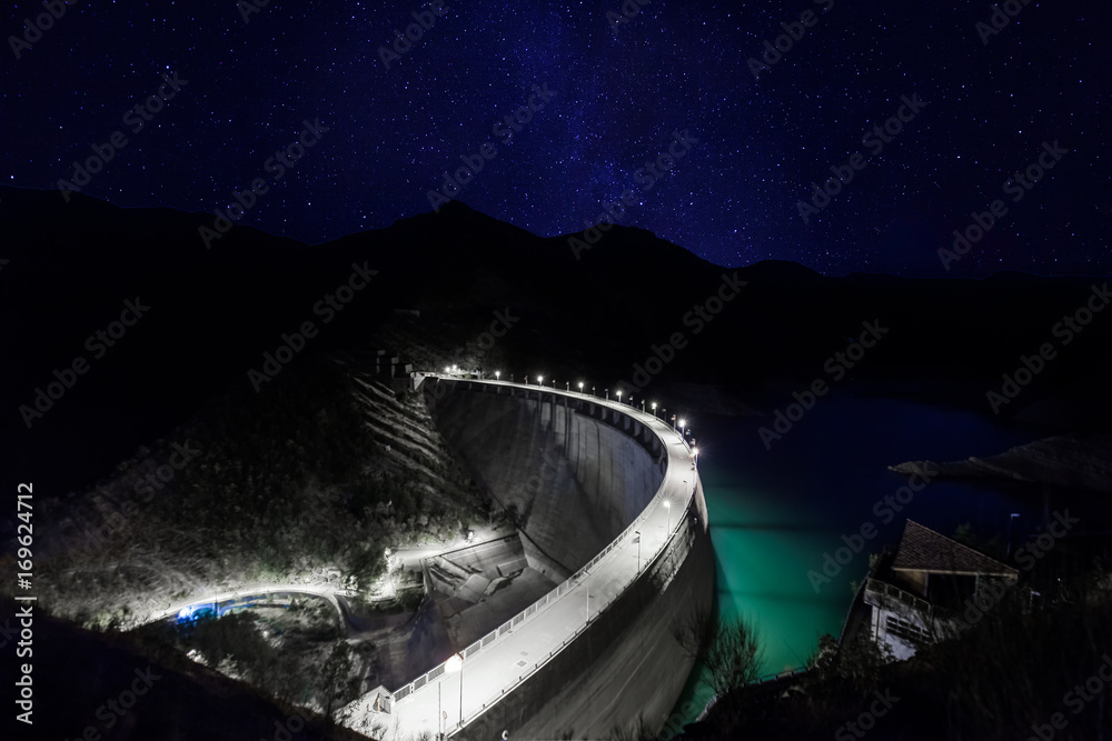 dam at night under starry sky and milky way