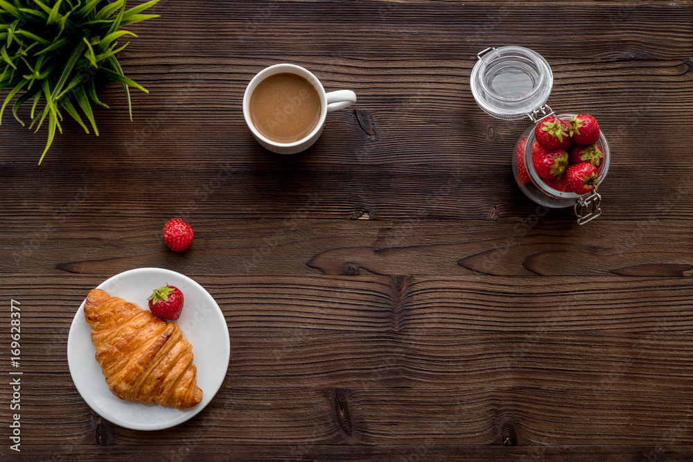 Light summer lunch. Coffee, strawberry, croissant on wooden background top view copyspace Light summer lunch. Coffee, strawberry, croissant on wooden background top view copyspace
