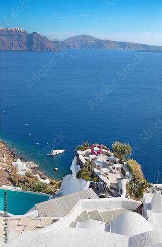 Santorini - The restaurant geared to wedding romantic diner in Oia (Ia) and the yacht under cliffs in the background.