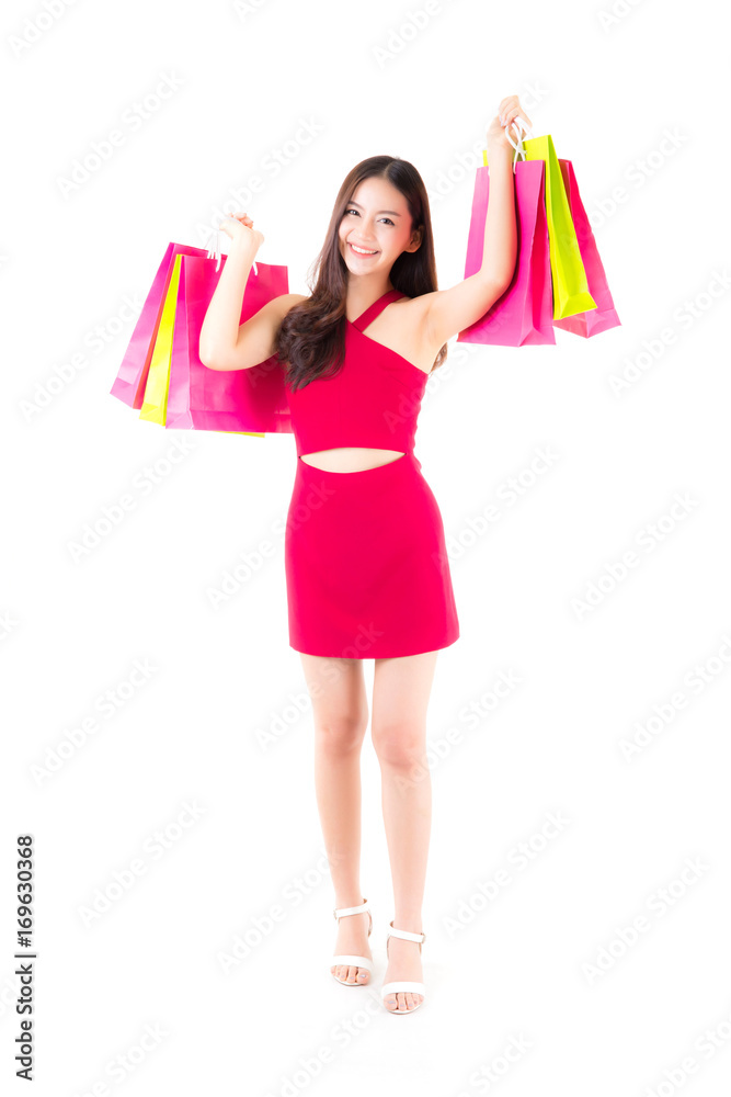 portrait of a happy excited asian woman in red dress standing and holding colorful shopping bags with happy isolated on a white background. portrait of a happy excited asian woman in red dress standing and holding colorful shopping bags with happy isolated on a white background.