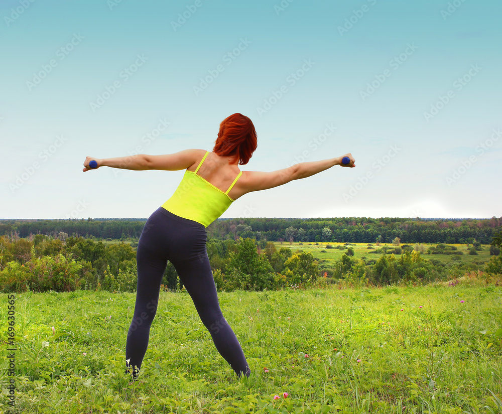 Sports exercising doing woman outdoors, on grass. The concept of a healthy lifestyle. Sports exercising doing woman outdoors, on grass. The concept of a healthy lifestyle.
