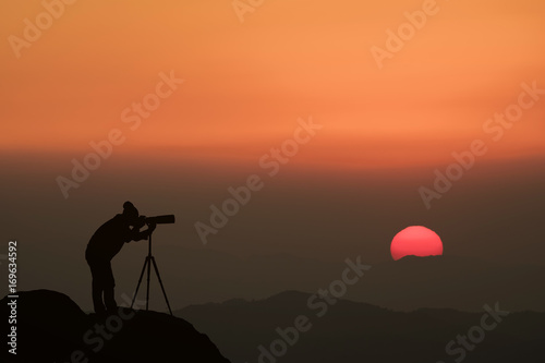 silhouette of a photographer who shoots a sunset