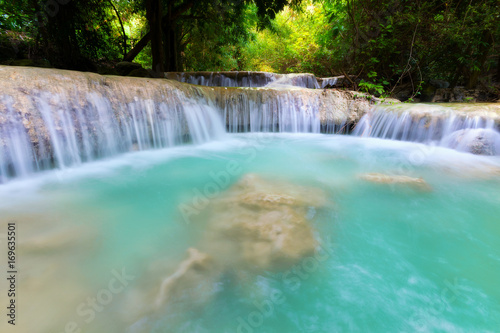 Waterfall in the jungle with lush greenery in the rainy season.