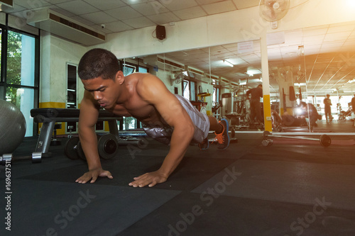 Fitness man showing push up exercises in gym