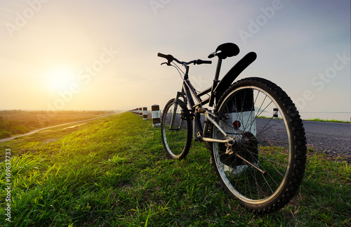 Fototapeta Naklejka Na Ścianę i Meble -  Bicycle on the way to landscape view at sunset.