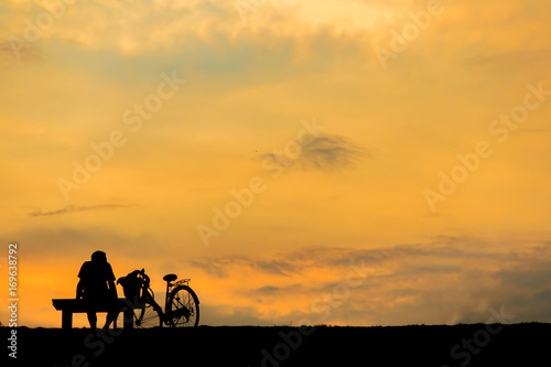 silhouette of man relax with bike happy time sunset