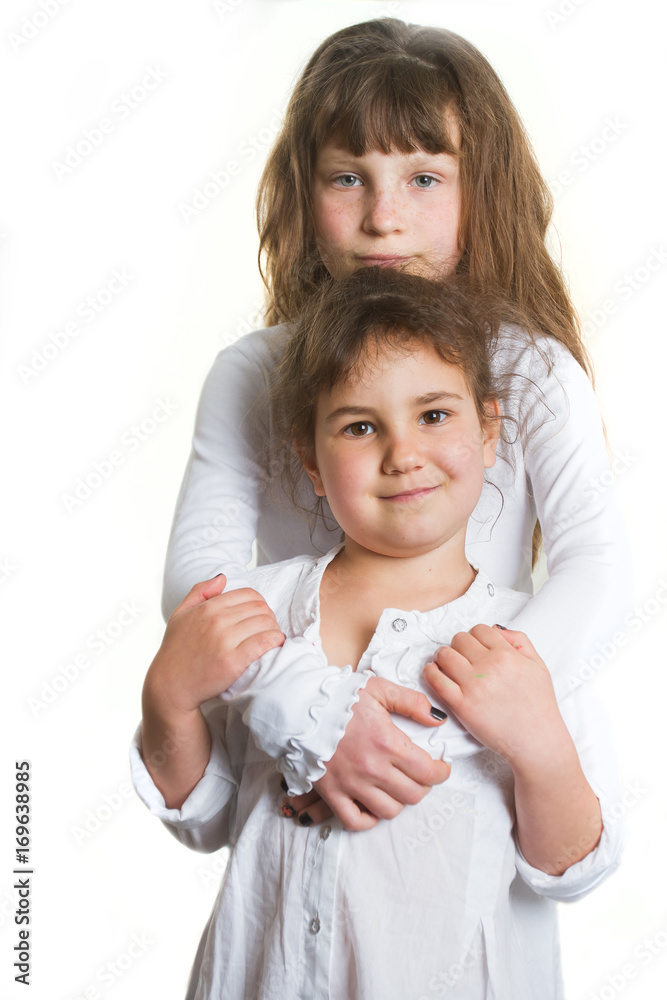 studio portrait of two young happy smiling girls, sisters, over white background studio portrait of two young happy smiling girls, sisters, over white background