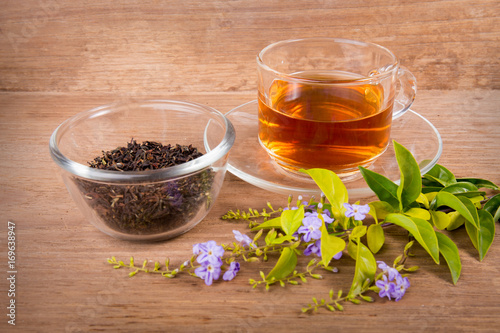 Cup of tea of dried tea leaves on wooden background