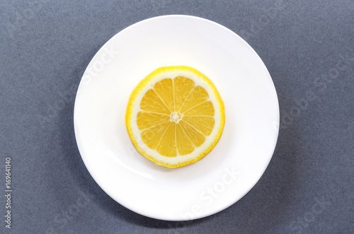 lemon with white dish on gray background.