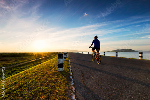 Men get healthy by cycling at sunset.
