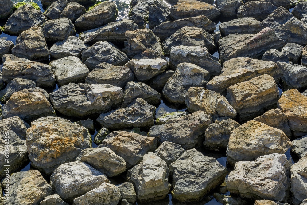 Stones and water background. Seashore with rocks in water on Black Sea.