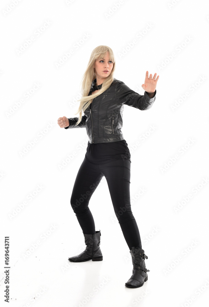 full length portrait of blonde girl wearing black leather outfit, standing pose on white background. full length portrait of blonde girl wearing black leather outfit, standing pose on white background.