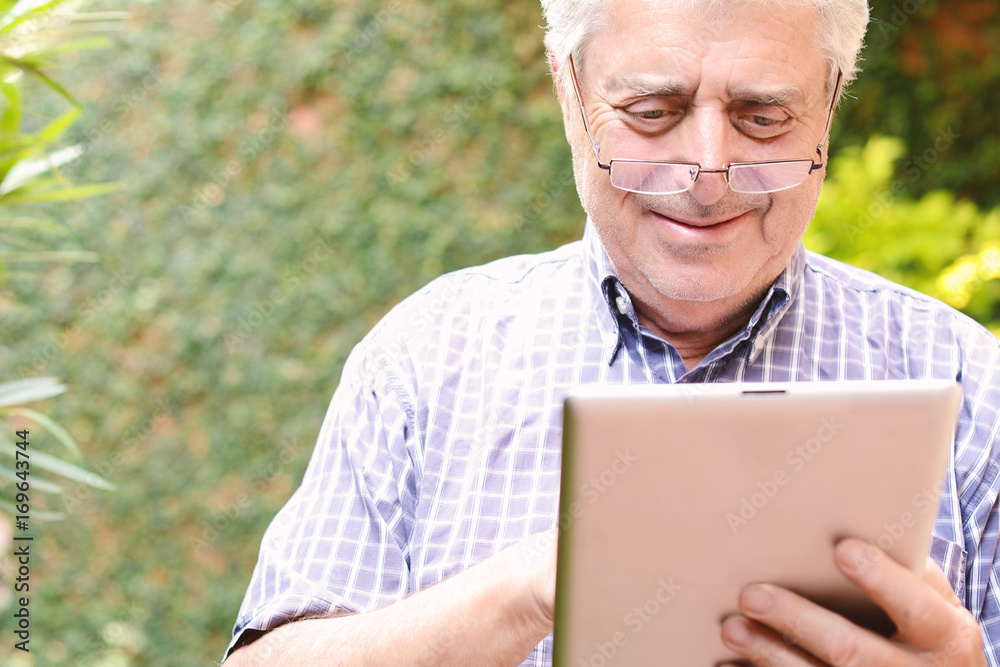 Old man using digital tablet. Old man using digital tablet.