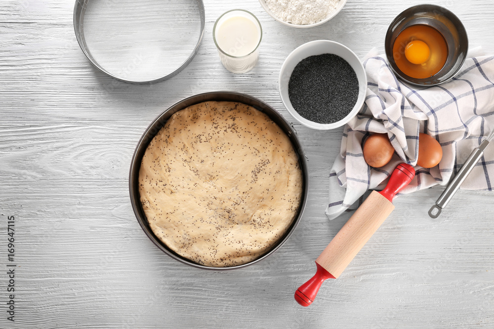 Baking form with raw dough and ingredients on kitchen table Baking form with raw dough and ingredients on kitchen table