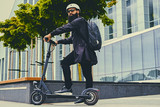 A man posing on electric scooter.