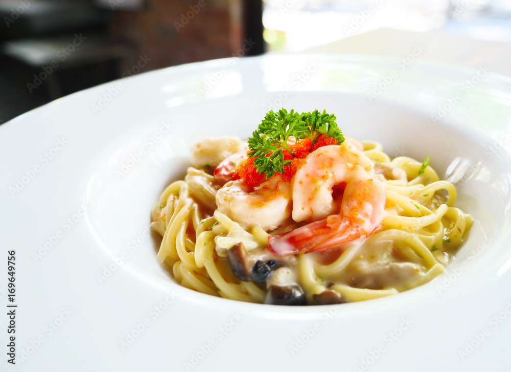 Spaghetti cream sauce with shrimp and mushroom on white dish, Spaghetti Ebiko cream. Selective focus.