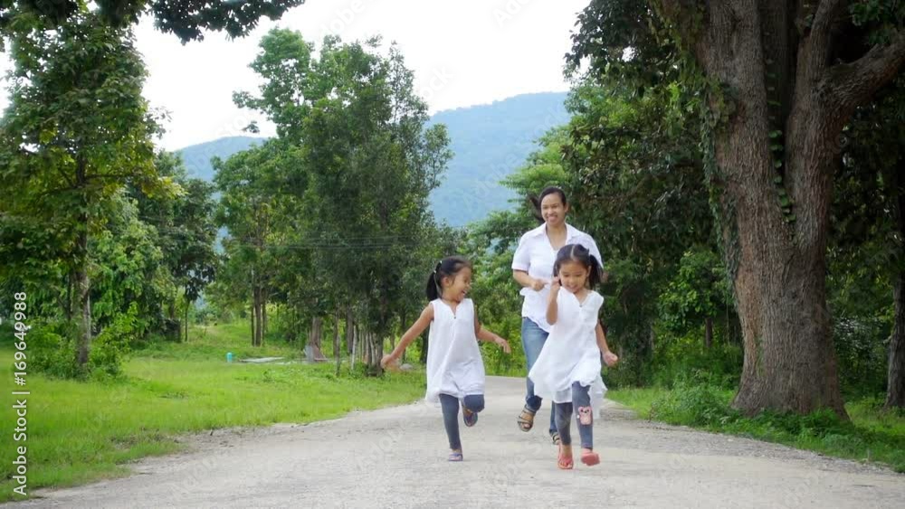 Asian family running in the park together. Concept the happiness family in freedom day. Asian family running in the park together. Concept the happiness family in freedom day.